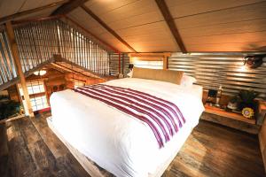 NogalCrows Nest Treehouse At El Mstico Ranch的铺有木地板的客房内一张大白色的床