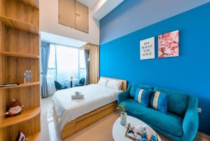 胡志明市S'Home Saigon - Infinity Pool Signature的蓝色的客房配有床和沙发