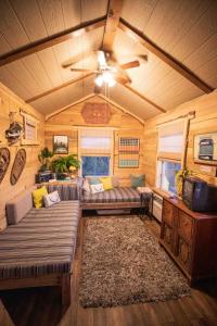NogalCrows Nest Treehouse At El Mstico Ranch的客厅配有两张沙发和吊扇