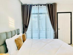 清迈Sky View Home and Hostel Chiangmai的卧室配有白色的床和窗户。
