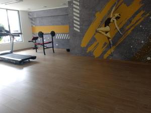 奇廉DEPARTAMENTO ARAUCO CENTRO CHILLAN Con ESTACIONAMIENTO的健身房设有跑步机和墙上的绘画