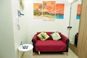 马尼拉Shore Residences MOA Dynastel Staycation的客厅配有红色的沙发和墙上的绘画