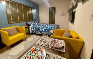 常滑市Kiwi House Tokoname VACATION STAY的客厅配有2把黄色椅子和1张床