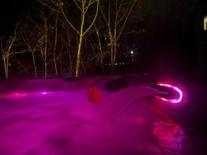 拉马巴耶Auberge musicale Pour un Instant的游泳池在晚上被粉红色的灯光遮盖
