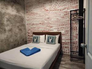 沙美岛Baan Minnie 2 bedroom home 400m from Saikaew beach的砖墙房间的一个床位