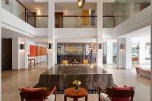 北芭堤雅Woodlands Suites Serviced Residences - SHA Extra Plus的大型客厅配有大桌子和椅子