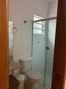 佩鲁伊比Casa em Peruíbe的一间带卫生间和玻璃淋浴间的浴室