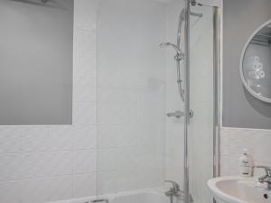 根斯堡The Gainsborough Mews的带淋浴和盥洗盆的白色浴室
