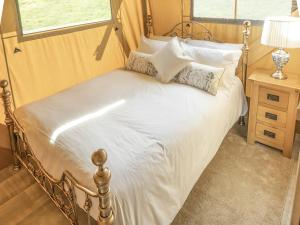 凯里堡Lime Kiln Lodge - Ukc6262的一间卧室配有带白色床单和枕头的床。