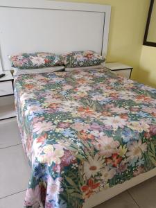 杰米斯顿AGNES GUEST HOUSE的一张带花卉床罩和枕头的床