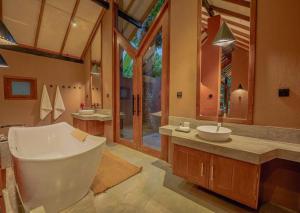 希克杜沃Nisala Villas的带浴缸和盥洗盆的大浴室
