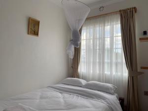 Naro MoruWarm and Inviting Mountain Cottage的卧室配有白色的床和窗户