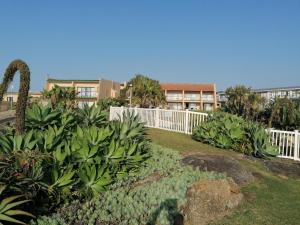 爱德华港Glenmore Sands Beach Resort的花园,有白色的围栏和一些植物