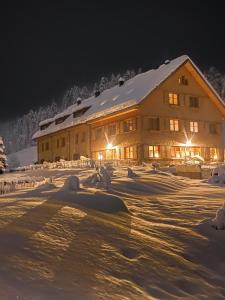 上施陶芬Gähwindehof Mountain Ranch Resort的一座大建筑物,在晚上下雪