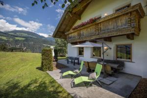 科利因普斯泰里亚Oberplunerhof Luxury Chalet Woods的房屋前设有带桌椅的天井。