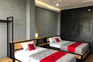 KembaranRedDoorz near Universitas Muhammadiyah Purwokerto 2的一间卧室配有两张带红白色枕头的床