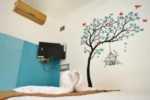 蓬蒂切里Paradise Feel Dreamy Resort的卧室,墙上有树,墙上有鸟笼