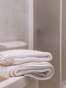 扎顿Adriana Zaton的浴室柜台上摆放着一堆白色毛巾