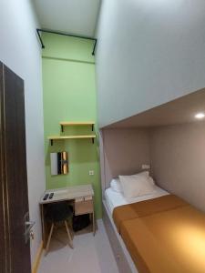 泗水Autumn Living Hotel的一间小卧室,配有一张床和一张书桌