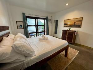 卢纳将军城Fat Lips Surf Lodge的一间卧室配有一张带白色床单的床和一扇窗户。