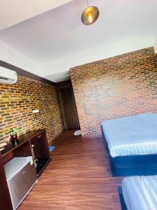 顺化Mandarin Homestay Hue的一间设有两张床和砖墙的房间