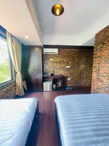 顺化Mandarin Homestay Hue的一间卧室设有一张床和砖墙