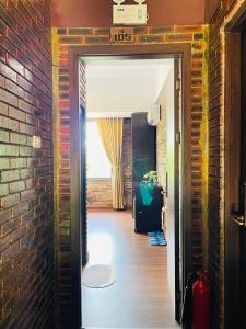 顺化Mandarin Homestay Hue的走廊上设有砖墙和一扇开放式门