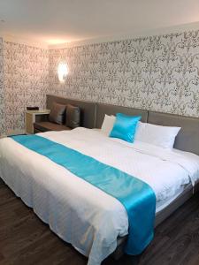 基隆恆昌商旅的一间卧室配有一张带蓝色毯子的大床