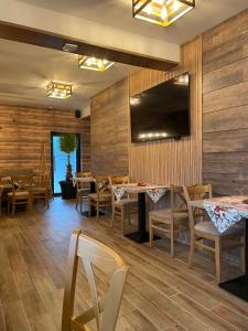 韦林格勒Zarevata Guest House的餐厅拥有木墙和桌椅