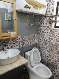 巴位Ba Vì Madela的浴室配有白色卫生间和盥洗盆。