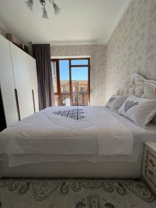 TürkistanKERUEN SARAY APARTMENTS 6/2的卧室配有一张大白色床和窗户