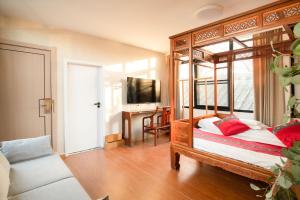 北京北京荣府老宅四合院精品酒店 的一间卧室配有一张木天蓬床和书桌