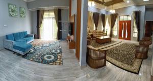 Kampung RajaTeratak Ammara Homestay Besut with private pool的客厅配有蓝色的沙发和桌子