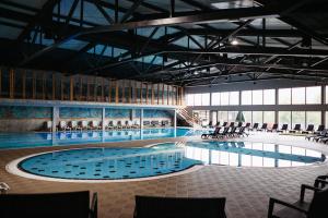 维特兹艾特诺村卡达西酒店的大楼内带椅子的大型游泳池