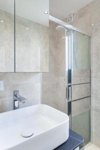 尚蒂伊Les appartements de Chantilly - gare的浴室配有白色水槽和淋浴。