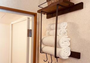横滨Yokohama Ivy 101 - 横浜 アイビー清水ヶ丘101 -的镜子旁毛巾架上的一大堆毛巾
