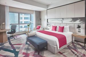 马尼拉Crowne Plaza Manila Galleria, an IHG Hotel的酒店客房设有一张大床和一张书桌。