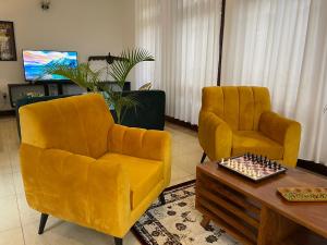 金贾The Jewel and the Lake的客厅配有两张黄色椅子和一张桌子