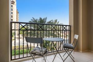 迪拜Stylish 1BR Apt Umm Suqeim 3的阳台配有两把椅子和一张桌子