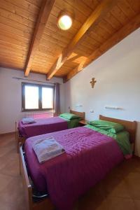 LàconiOASI FRANCESCANA SANT'IGNAZIO DA LACONI的客房设有两张床和木制天花板。