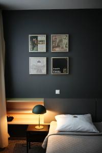 克莱佩达Hotel Navalis, Klaipėda的一间卧室设有一张黑色的墙壁、一张床和一张书桌