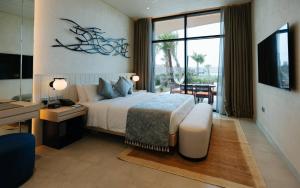 阿布扎比Bab Al Nojoum Hudayriyat Villas的一间卧室配有一张床、一张书桌和一台电视