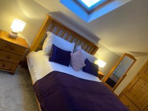 HaxbyThe Barn的一间卧室配有一张带蓝白色枕头的大床