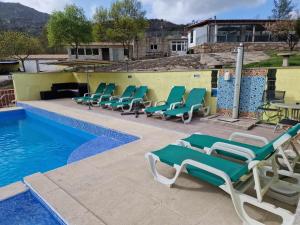 Aldeia Viçosa金塔多米奥旅馆的游泳池旁的一排躺椅