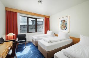 惠拉盖尔济奥克酒店的酒店客房设有两张床、一张书桌和一个窗户。