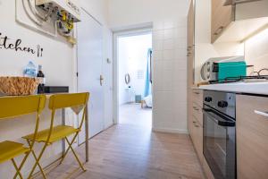蒙扎Cozy Apartment in Monza City Center的厨房配有黄色椅子和柜台