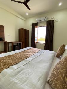 奥拉奇哈Hotel saanjh haveli的一间卧室设有一张大床和一个窗户。