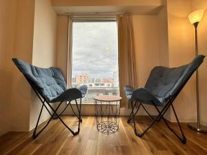 札幌【NEW OPEN】AMS Hiragishi R401的窗户客房内的两把椅子和一张桌子