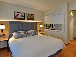 雾观ANEW Resort Hazyview Kruger Park的卧室设有一张白色大床和一扇窗户。