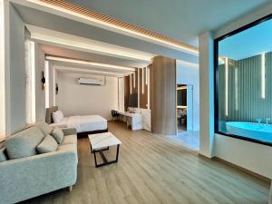 拉差汶里Rock Resort Ratchaburi的带沙发、床和浴缸的客厅